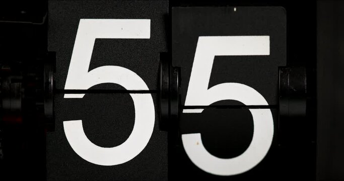 Flip clock countdown fifty-five white numbers turning fifty-six on black background.