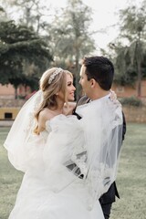 Fototapeta premium Feliz pareja abrazados velo de novia