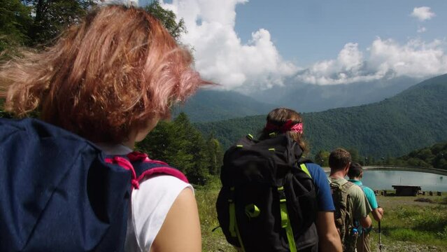 Scientists team approach comfortable research base on the shores of mountain lake. Hiking scientific expedition in a remote area from civilization