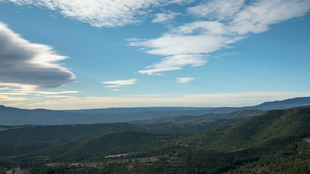 timelapse de nubes sobre un valle frondoso y montañas.