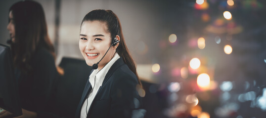 Asian woman in headset, sitting in office, working as operator of call center or support customer...