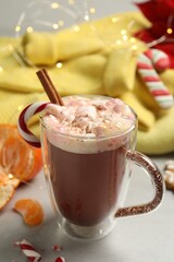Composition with delicious marshmallow drink, festive items and yellow sweater on light table