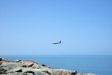 Modern airplane flying in sky over sea