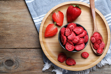 Freeze dried and fresh strawberries on wooden table, top view. Space for text