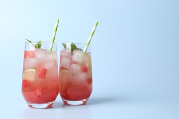 Tasty summer watermelon drink with lime in glasses on pale light blue background. Space for text