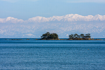 冬の氷見海岸から日本海越しの雪の立山連峰
