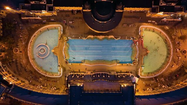 4K aerial drone view Szechenyi Bath. Drone flies around pool with many visitors. Budapest, Hungary