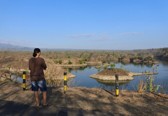 A Man walking around Waduk Bajulmati in Situbondo, East Java, Indonesia.
