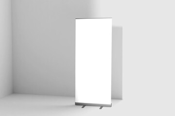 Blank white roll-up banner display mockup on wall background, isolated, 3d rendering. Ready to display your design