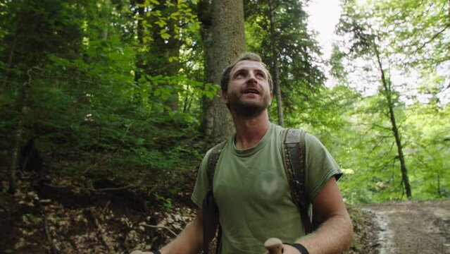 Young man enjoys the view of the blue sky from mountain road. Look up. Solo trip to mountains, getting used to shitty microclimate, acclimatization