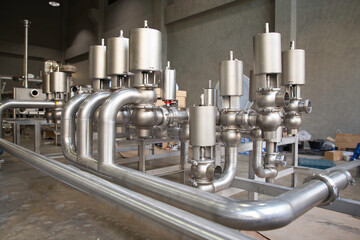 Stainless steel control valves in piping systems for the food and beverage industry.