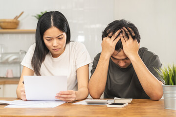 Fototapeta premium Stressed asian young couple family, wife and husband confused by calculate expense from invoice or bill, have no money to pay. Mortgage, loan causing debt, bankruptcy. Debt problems, Financial people.