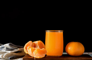glass of fresh orange juice with fresh fruits on dark background, high Vitamin C, orange drink