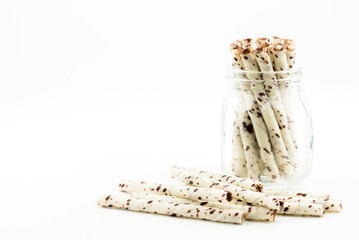 wafer rolls with chocolate in glass white background