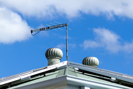 Solar panels, tv antenna, and two roof whirly birds.