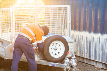 Tradie in golden light opening up lock box on trailer