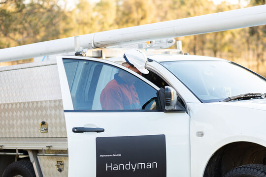 man with hard hat getting into handyman maintenance services vehicle