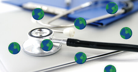 Image of falling globe icons over medical equipment