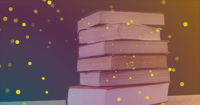 Image of yellow spots over books on black background - Powered by Adobe