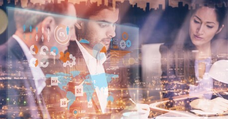 Digital interface with data processing over businesspeople working against cityscape at night