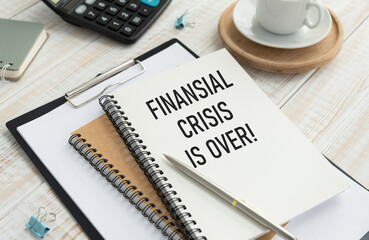 FINANCIAL CRISIS IS OVER, business concept. text on checkered paper on the desktop