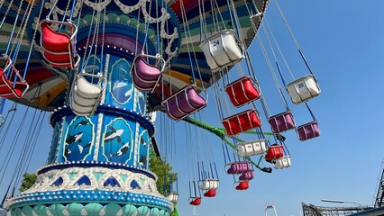 Empty bright swing Carousel chain on the background of the sky is spinning without people Sadness...