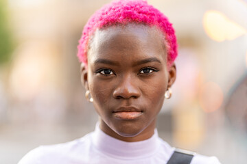 African woman with short pink hair outdoors