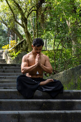 young man doing meditation on a stairway in a forest, mexico