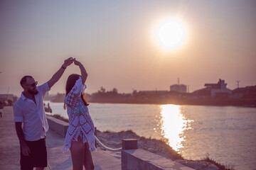 Fototapeta premium Pregnant couple dancing at sunset