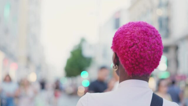Back of an afro woman walking in the street