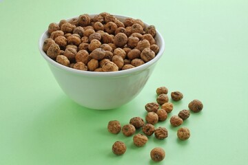 Chufa, tigernut, earth almond on ceramic bowl on green background. Healthy organic food concept. Tiger nut for flour, milk, traditional typical homemade cold fresh drink horchata from Valencia Spain
