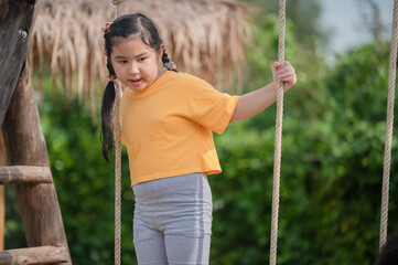 Asian Girl playing on playground, happy little Asia girl child having fun to playing in the playground