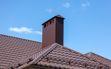 Brown metal pipe on the roof of the house