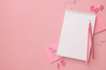 School supplies accessories stationery on pink background, flat lay, top view. Education supply accessory open empty notebook stuff. Back to school concept. Flatlay from above. Copy space.