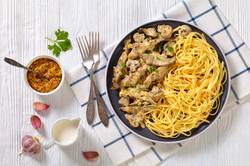 liver stroganoff with spaghetti on plate, top view