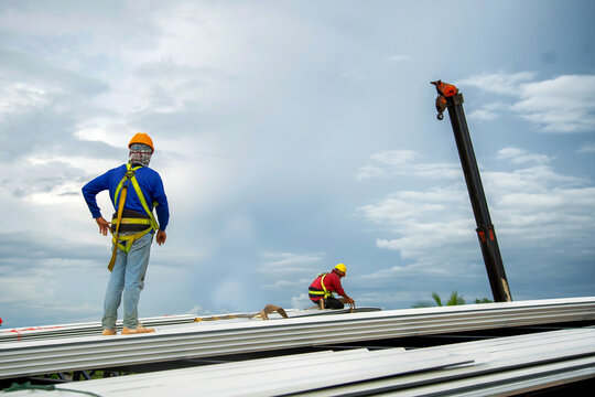 Asian Construction Worker Holding Metal Sheet Installation Tool To Build Industrial Factory Roof