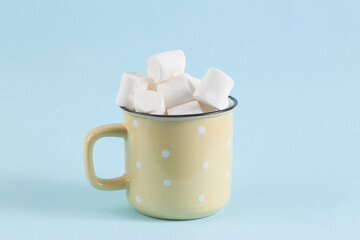 Cup with marshmallows on a blue background