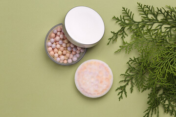 Obraz na płótnie Canvas Balls powder with fir sprig on green background. Natural cosmetics concept. Top view