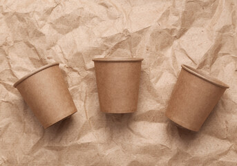 Cardboard cups on crumpled craft paper background. Zero waste simple creative concept. Trendy eco things. Top view, Flat lay