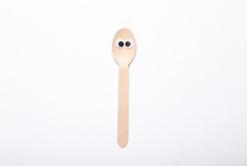 Wooden spoon with eyes on white background. Eco concept