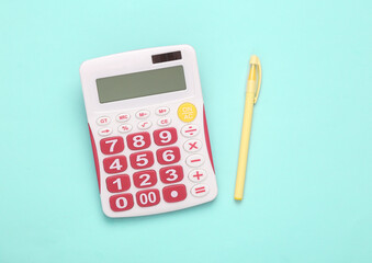 Calculator with pen on blue background. Business concept. Top view