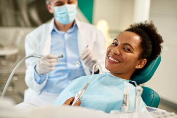Happy black woman at dentist's office looking at camera.