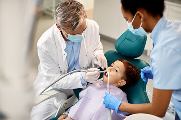Obraz premium Small kid during dental procedure at pediatric dentistry clinic.