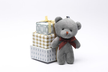 Stack of christmas gift boxes with teddy bear on white background