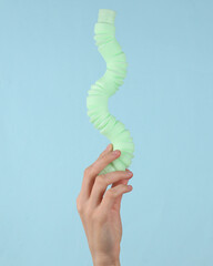 Pop tube sensory antistress toy in female hand on a blue background.