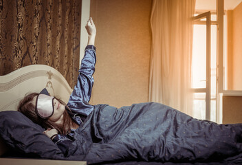 Young woman in sleeping mask sleeping on the bed