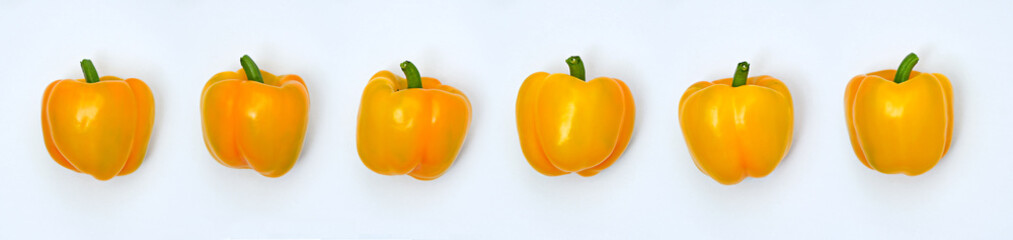 A line of Yellow Bell Peppers isolated on white background