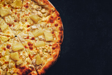 Pizza with cheese, pineapple and chicken on a dark background