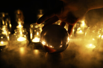 Black background with a ball and candles. Divination and prediction of fate.