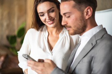 Young business executive man and his secretary standing in office discussing about new social and communication strategy